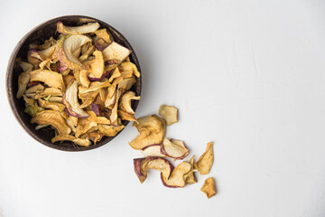 Homemade crispy sun dried organic apple slices. Close up of apple chips with spice in bowl isolated on white background with copy space for text