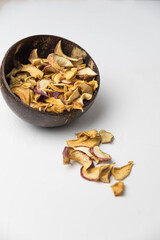 Homemade crispy sun dried organic apple slices. Close up of apple chips with spice in bowl isolated on white background with copy space for text