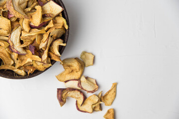 Homemade crispy sun dried organic apple slices. Close up of apple chips with spice in bowl isolated on white background with copy space for text