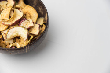 Homemade crispy sun dried organic apple slices. Close up of apple chips with spice in bowl isolated on white background with copy space for text