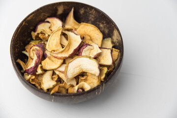 Homemade crispy sun dried organic apple slices. Close up of apple chips with spice in bowl isolated on white background with copy space for text