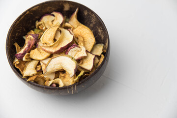 Homemade crispy sun dried organic apple slices. Close up of apple chips with spice in bowl isolated on white background with copy space for text