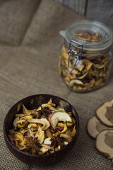 Homemade crispy sun dried organic apple slices. Close up of apple chips with spice in bowl on brown wooden background with copy space for text