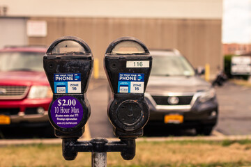 Old historic parking meter before blue car in Buffalo parking place
