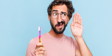 young bearded man looking serious and curious, listening, trying to hear a secret conversation or...
