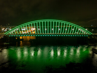 Aerial drone view. Modern arch cable-stayed bridge in Kiev in the evening. Colored lighting of the...