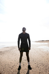 Black sportsman boy looks up to the sky while resting from running. Concept of health and sport.