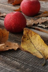 Juicy red apples and autumn leaves on the table