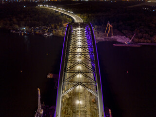 Aerial drone view. Modern arch cable-stayed bridge in Kiev in the evening. Colored lighting of the...