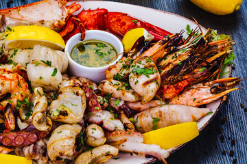Seafood platter.Grilled lobster, shrimps, scallops, langoustines, octopus, squid on white plate.