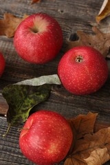 Juicy red apples and autumn leaves on the table