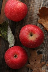 Juicy red apples and autumn leaves on the table