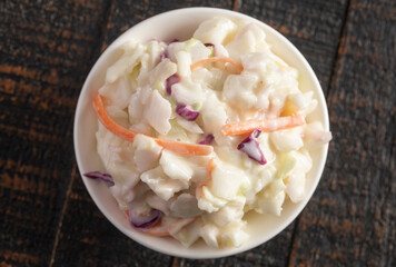 Bowl of Traditional Coleslaw on a Rustic Wooden Table