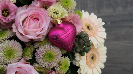very beautiful fresh bouquet with pink roses and a distinguished love heart bauble