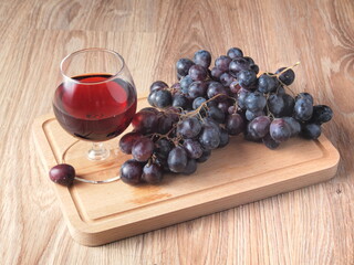 a bottle of red wine and a vine