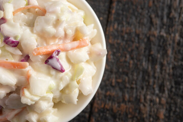 Bowl of Traditional Coleslaw on a Rustic Wooden Table