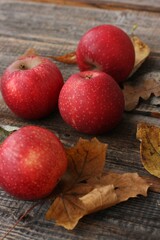 Juicy red apples and autumn leaves on the table