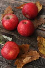 Juicy red apples and autumn leaves on the table