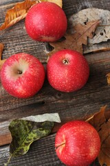 Juicy red apples and autumn leaves on the table