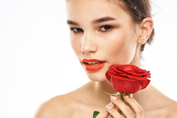 Beautiful woman with red rose near face makeup naked shoulders portrait