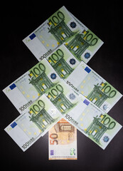 Cash in the form of a Christmas tree. Happy new year and merry Christmas. Banking and Finance. Christmas tree made of European currency banknotes in green on a black background.