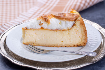 Homemade german cheesecake on beautiful plate on white table.