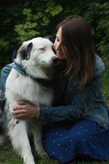  Australian shepherd sittingg on the grass with Woman face to face