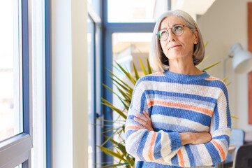 middle age woman looking puzzled and confused, wondering or trying to solve a problem or thinking