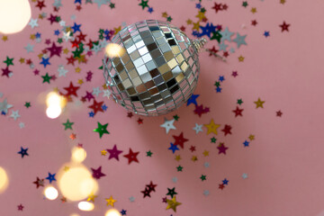 silver disco ball reflecting lights on pink background, greeting card with sparkles template, empty...