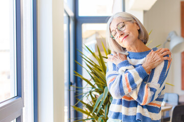 middle age woman feeling in love, smiling, cuddling and hugging self, staying single, being selfish...