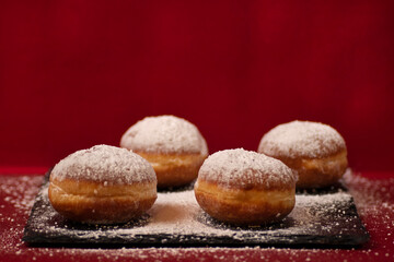 Four donuts with powdered sugar