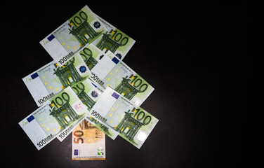 Cash in the form of a Christmas tree. Happy new year and merry Christmas. Banking and Finance. Christmas tree made of European currency banknotes in green on a black background.