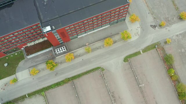 Empty car park lot after closure. Covid 19 Coronavirus Isolation home office working from home effect. Drone aerial view of deserted parking stalls in front of large office building. Stockholm Sweden 