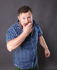 Joyful bearded man in shirt whistling studio portrait