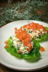 Olivier salad with salmon on a wooden table
