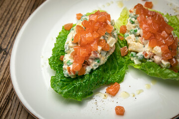 Olivier salad with salmon on a wooden table
