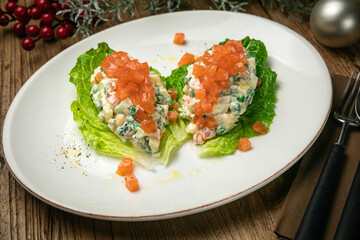 Olivier salad with salmon on a wooden table
