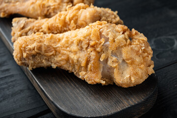 Fried crispy chicken legs, drumstick  on black wooden table