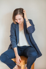 Fototapeta premium Sitting smiling business European woman in blue costume