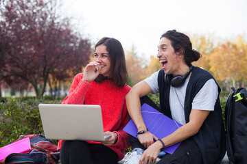 Two young students studying outdoor wearing mask during coronavirus times