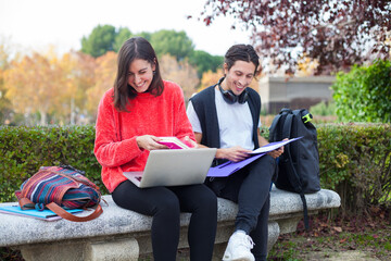 Two young students studying outdoor wearing mask during coronavirus times