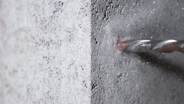 Super slow motion of detail of a drill bit drilling into concrete. Filmed on very high speed cinema camera, 1000 fps.
