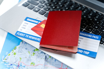 Online ordering, buying tickets in laptop for flight to nowhere. Special travel, round trip during covid-19 coronavirus pandemic. Paying by credir card. Boarding pass, passport, city map