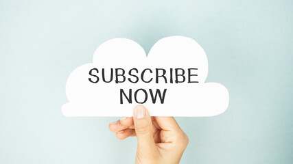 SUBSCRIBE NOW text on paper in the form of a cloud in hand.
