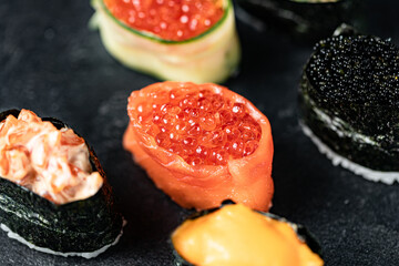 Sushi Rolls Set, maki, philadelphia and california rolls, on a Black background.