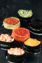 Sushi Rolls Set, maki, philadelphia and california rolls, on a Black background.