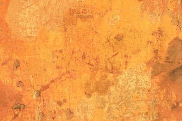 A large fragment of the orange clay wall of the old house with cracks and roughness, exfoliating part of the plaster. Vintage background. Rough flushed texture. Space to copy text.