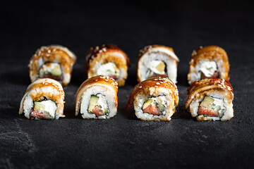 Sushi Rolls Set, maki, philadelphia and california rolls, on a Black background.