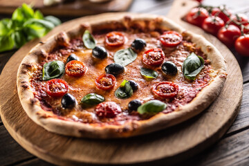 Homemade pizza with tomatoes mozzarella cheese olives and basil