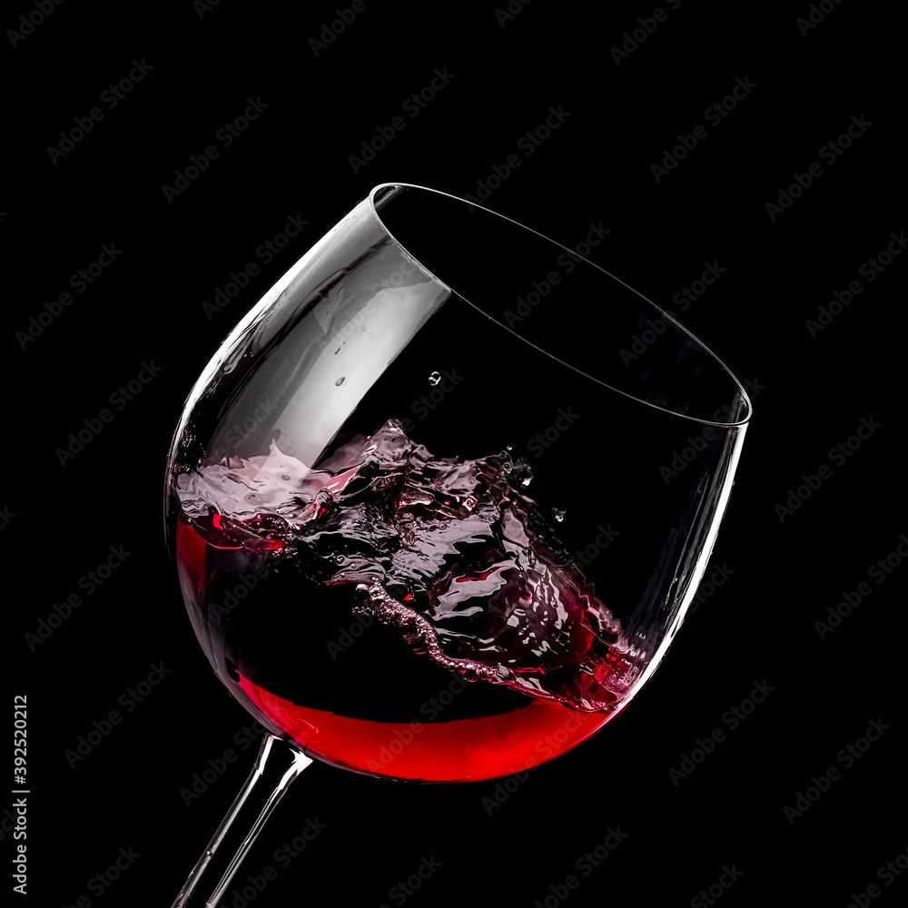 Wall mural red wine glass plash on black background